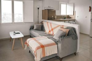 a living room with a couch and a table at Santorini's Old Mill Serene Getaway by Pori Beach in Vourvoulos