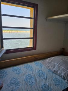 RARE maison du pêcheur en première ligne avec clim في لو باركار: غرفة نوم بها سرير ونافذة كبيرة