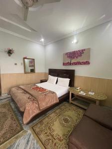 a bedroom with a bed and a table and a couch at lake view hotel and resort in Khānpur +44 photos