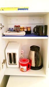 a shelf with a coffee maker and a coffeemaker at A&A Lodge Motel in Emerald