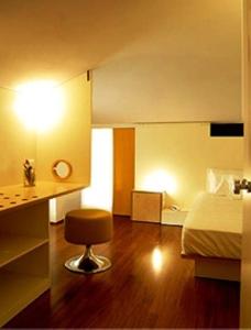 - une chambre avec un lit et un tabouret dans l'établissement Il Bocciolo Della Rosa, à SantʼAgostino