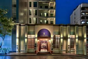 a hotel entrance with a building in the background at Radisson Suites Bangkok Sukhumvit in Bangkok