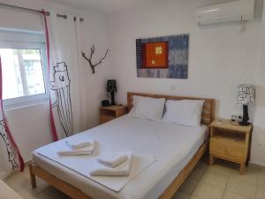 a bedroom with a bed with two towels on it at The old Phone Center house in Ierápetra