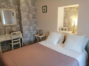 ein Schlafzimmer mit einem Bett, einem Schreibtisch und einem Spiegel in der Unterkunft Le Verger in Marigné-Peuton + 43 Fotos