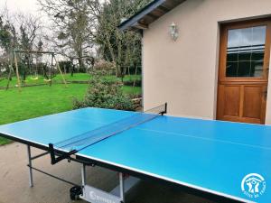 a ping pong table in front of a house at Le Verger in Marigné-Peuton