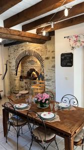 ein Esszimmer mit einem Tisch und einem Steinofen in der Unterkunft Le Verger in Marigné-Peuton