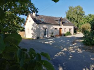 ein großes weißes Haus mit einer Auffahrt in der Unterkunft Le Verger in Marigné-Peuton