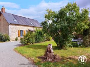 un tronco di albero di fronte a una casa di La Pichardière a Montsûrs