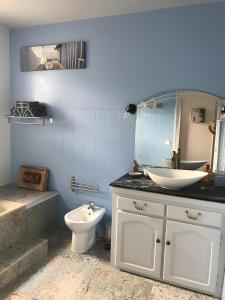 un bagno con lavandino, WC e specchio di Chambre D'hote Chez Amaya a Gujan-Mestras