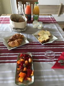un tavolo con piatti di cibo e frutta sopra di Chambre D'hote Chez Amaya a Gujan-Mestras Altre 2 foto