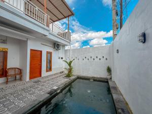 a swimming pool in the courtyard of a house at Vins Family Homestay in Tumbak Bayuh