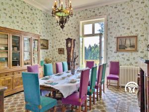 a dining room with a table and colorful chairs at Château de la Roche, 11-12 personnes in Ahuillé