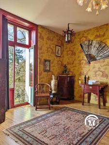 a living room with yellow walls and a rug at Château de la Roche, 11-12 personnes in Ahuillé +42 photos