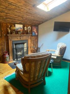 a living room with a fireplace and a chair at Cabana Vanatorului 8 in Râşnov +20 photos