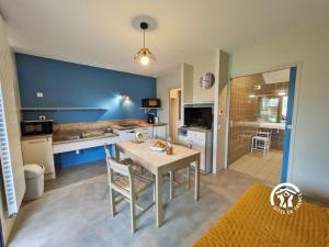a kitchen and dining room with a table and a sink at Chalet le Vairon (PMR) in Villiers-Charlemagne