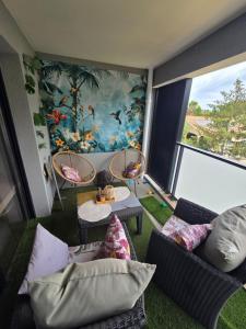 a living room with a couch and chairs and a mural at Appartement bella vista marseillan in Marseillan