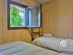 a bedroom with a bed and a window at Chalet 26 Le Berthevin, Camping de Coupeau, 4 personnes in Saint-Berthevin