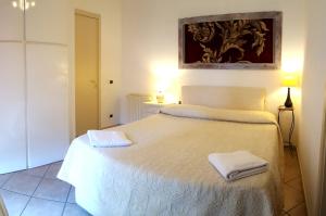 a bedroom with a white bed with two towels on it at Derosas House in Golfo Aranci