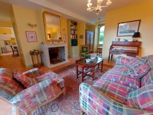 a living room with a couch and a piano at Les Buis de Chantepie, gîte 4 personnes 