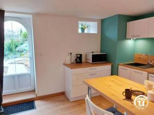 eine Küche mit einem Holztisch und einem Tisch und einem Fenster in der Unterkunft L'étoile du Berger in Montsûrs + 18 Fotos