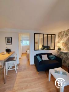 ein Wohnzimmer mit Sofa und Tisch in der Unterkunft L'étoile du Berger in Montsûrs