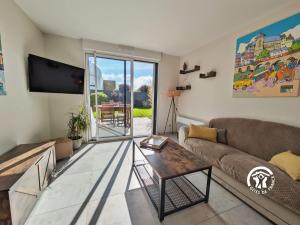 a living room with a couch and a tv at Le Pêcheur d'étoiles in Origné