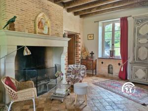 a living room with a fireplace and a window at Le Moulin Renaud, 8 personnes 