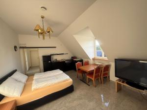 a room with a bed and a table and a television at Hof König in Everswinkel