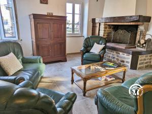 un soggiorno con mobili in pelle e un camino di Gîte du Lavoir, 8 personnes a Chammes