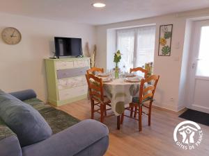 a living room with a dining room table and chairs at La Douce Escapade in Andouillé