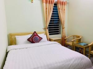 a bedroom with a white bed and a window at Tùng Long Hotel in Thanh Hóa