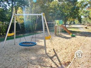 a playground with a swing set in a park at Chalet l'Ablette in Villiers-Charlemagne