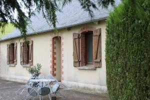 a table with flowers on it in front of a house at La Grande Perrine in Athée