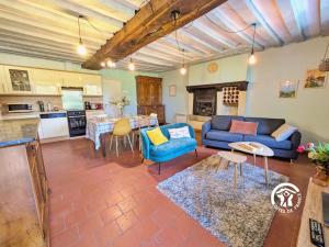 a living room with blue couches and a kitchen at La Grande Perrine in Athée