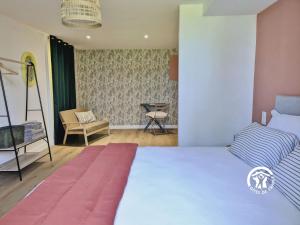 a bedroom with a bed and a chair at La Grande Perrine in Athée