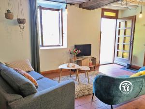 a living room with a couch and a table at La Grande Perrine in Athée