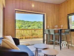 a living room with a table and chairs and a large window at Chalet 23 Le Moulin, Camping de Coupeau, 4 personnes in Saint-Berthevin +18 photos