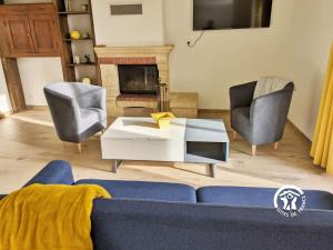 ein Wohnzimmer mit einem blauen Sofa und 2 Stühlen in der Unterkunft La Musette, jusqu'à 7 pers in Hambers