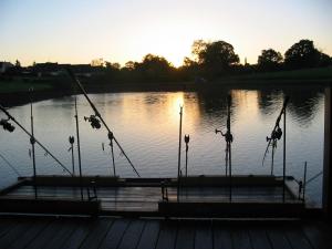 a dock on a lake with the sun setting at Chalet la Brême in Villiers-Charlemagne
