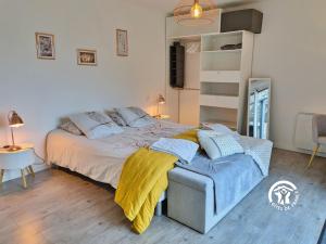 une chambre avec un grand lit avec une couverture jaune dans l'établissement La Lande du Pont, à Hambers