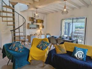 un salon avec des chaises jaunes et un escalier en colimaçon dans l'établissement La Lande du Pont, à Hambers