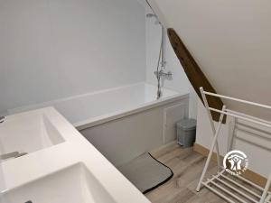 ein weißes Zimmer mit einer Treppe und einem Waschbecken in der Unterkunft La Janvrie, 5 personnes in La Rouaudière
