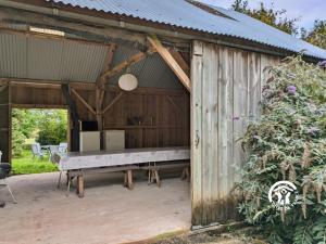 a wooden shed with a bench in it at La Janvrie, 5 personnes in La Rouaudière