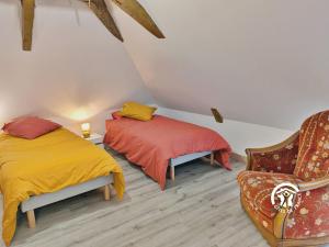 2 Betten in einem Zimmer mit Sofa und Stuhl in der Unterkunft La Janvrie, 5 personnes in La Rouaudière