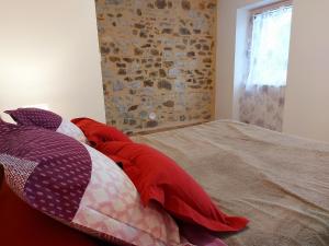 a bedroom with a bed with red and white pillows at Un air de campagne in Saint-Pierre-la-Cour
