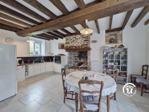 a kitchen with a table and chairs in a room at Les gallinettes in Neuilly-le-Vendin