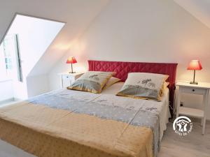 a bedroom with a large bed with two lamps at Les gallinettes in Neuilly-le-Vendin