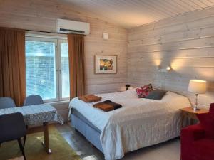 a bedroom with a bed in a room with wooden walls at Modern holiday cabin in Saimaa in Enonkoski