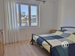 een slaapkamer met een bed en een raam bij La maison de Sainte Suzanne, 5 pers in Sainte-Suzanne