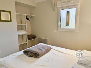 a white bed in a room with a window at Chalet la Tanche in Villiers-Charlemagne